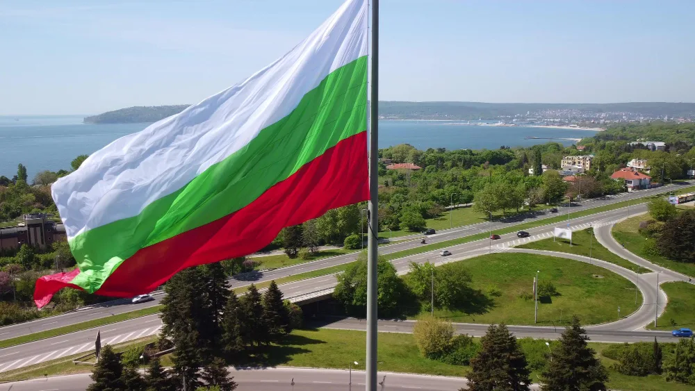 Развивающийся флаг Болгарии на фоне побережья