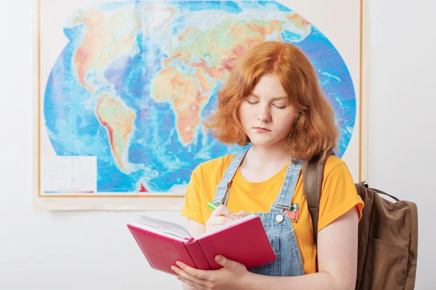 Девушка читает книгу на фоне карты мира