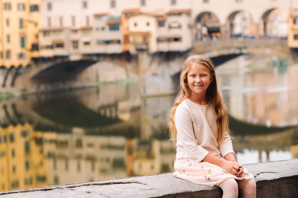 Девочка сидит перед рекой
