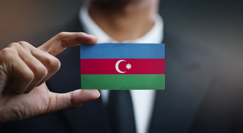 Мужчина держит карту в виде флага Азербайджана
