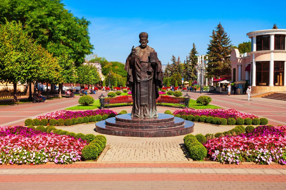 Памятник на фоне клумб и пешеходной улицы в Кисловодске